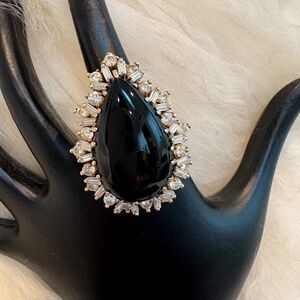 18K Gold ring with center onyx stone surrounded by diamonds.
